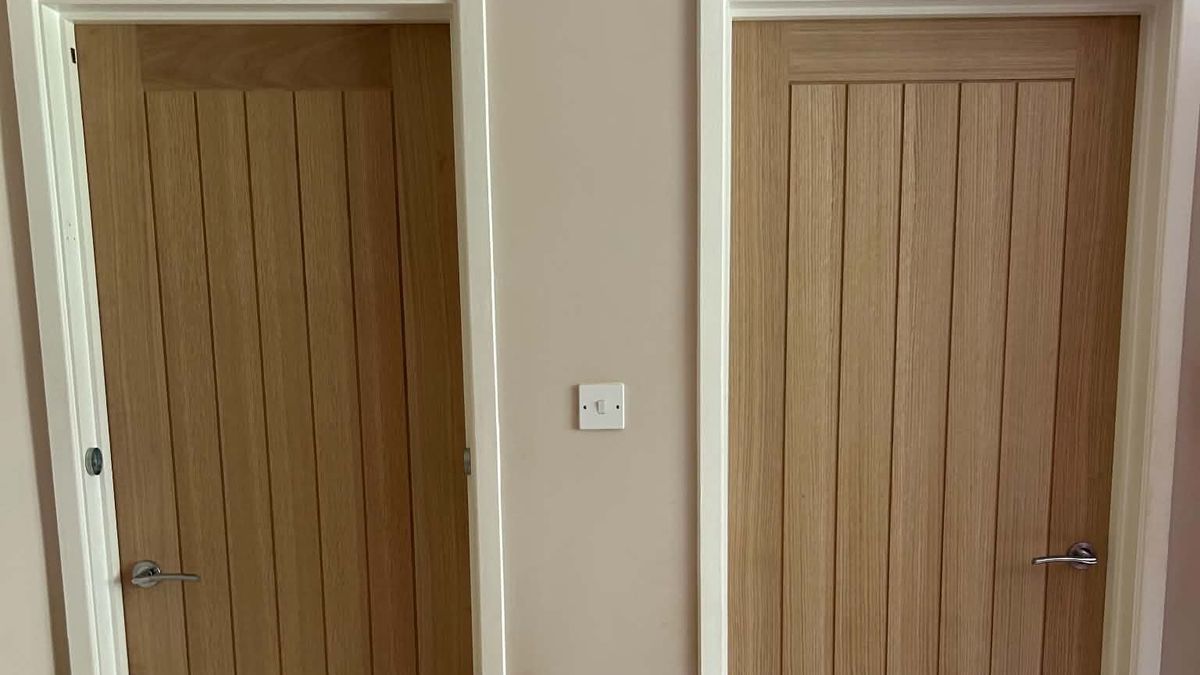 Two oak internal doors with chrome handles on a carpeted landing