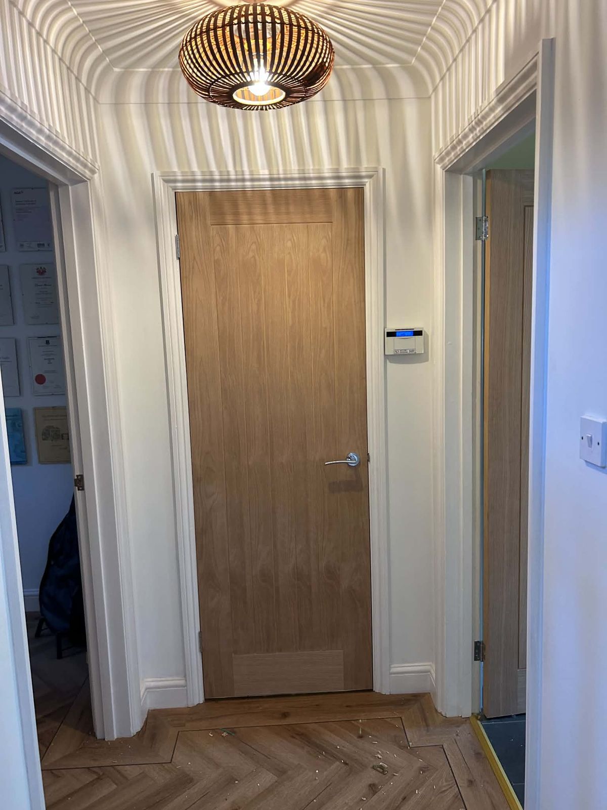 Oak internal door in a hallway with a herringbone wood floor